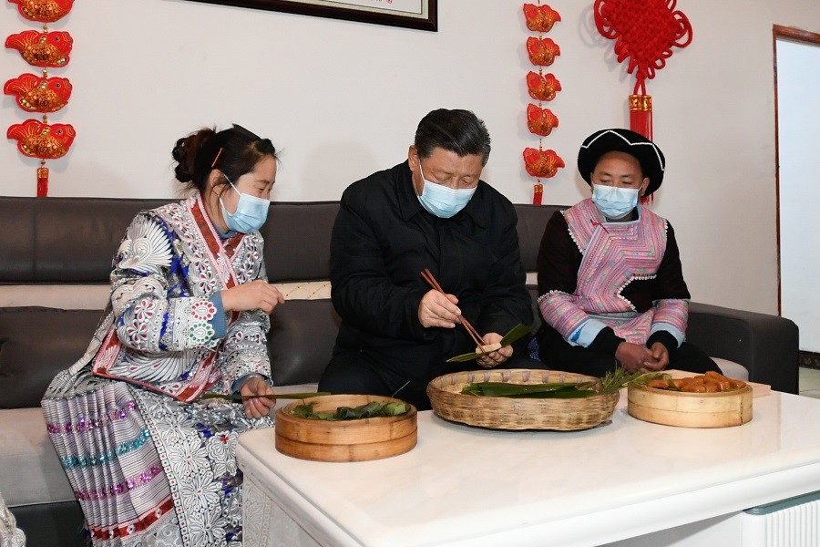 2021年2月3日下午，習近平在貴州畢節(jié)市黔西縣新仁苗族鄉(xiāng)化屋村苗族村民趙玉學家，同一家人邊聊家常邊制作當?shù)貍鹘y(tǒng)節(jié)日食品黃粑。新華社記者 李學仁 攝